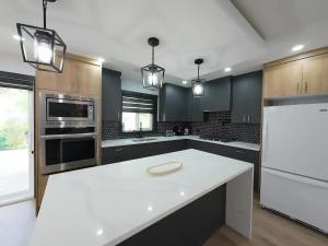 a large kitchen with a white counter top and appliances at The Luxe Escape Calgary I 3BR Vacation Home in Calgary
