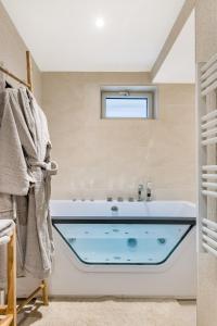 a bath tub in a bathroom with a window at xx Le Frappa xx Loft & Spa City in Saint-Étienne