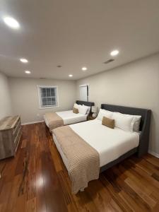 two beds in a room with wooden floors at Love at First Sight Retreat Luxury 4 bed 4 bath near DC Family Home in Annandale