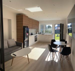 a living room with a couch and a table and chairs at Apartamenty Na Kowańcu in Nowy Targ