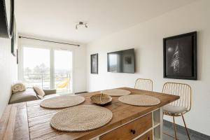 a dining room with a wooden table and chairs at Geneva Téléphérique Flat in Étrembières