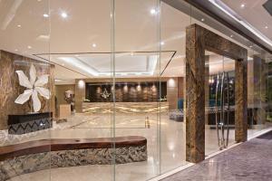 eine Lobby eines Hotels mit einer Glaswand in der Unterkunft Ayaka Suites in Jakarta