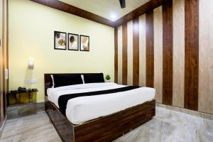 Un dormitorio con una cama grande con una pared de madera. en HOTEL O ELEGANT, en Prayagraj