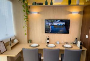 uma mesa de jantar com cadeiras e uma televisão na parede em Luxo Novo e Aconchegante entre Pinheiros e Jardins em São Paulo mais 38 fotografias