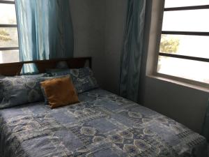 une chambre avec un lit avec une couverture bleue et une fenêtre dans l'établissement Sunset Cabin, à Twin Lakes