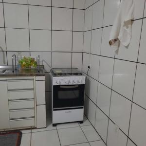 a white kitchen with a stove and a sink at Apartamento aconchegante em Cuiabá in Cuiabá