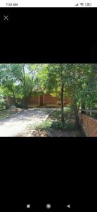a view of a park with trees and a building at Cabaña con piscina compartida in Mina Clavero