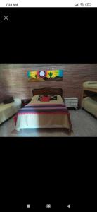a bedroom with a bed with a colorful head board at Cabaña con piscina compartida in Mina Clavero
