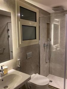 a bathroom with a shower and a toilet and a sink at شقة فندقية فى الشيخ زايد داخل كمبوند حديقة خاصة ومدخل خاص in Sheikh Zayed