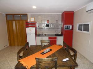 a kitchen with a wooden table and a red refrigerator at Cabañas EL BOSQUE in Malargüe