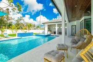 a swimming pool with chairs and a house at Blue Diamond Beach Home in Bonita Springs