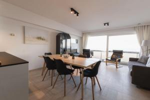 a dining room and living room with a table and chairs at Cadiz 0602 in Sint-Idesbald