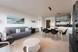 a living room with a couch and a table and chairs at Cadiz 0602 in Sint-Idesbald