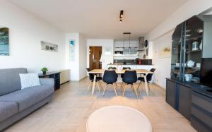 a living room and kitchen with a table and chairs at Cadiz 0602 in Sint-Idesbald +12 photos