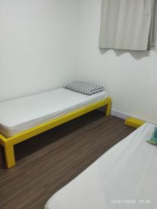 a bed with a yellow frame in a room at Mi casa su casa 5 in Londrina