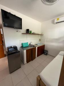 Elle comprend une petite cuisine avec un évier et une télévision murale. dans l'établissement Apartaestudio Playa Linda 101, à Coveñas