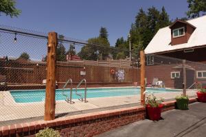 a swimming pool with a fence around it at Sleepy Hollow Cabins and Hotel in Crestline