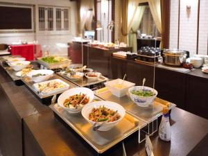 a buffet line with bowls of food in a restaurant at Hotel Grand Terrace Toyama in Toyama