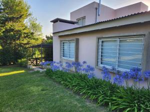 a house with purple flowers in the yard at Dúplex La Falda in La Falda