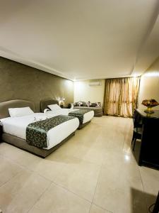 伊尔富德Palm's Hotel Club的有两张床和一张沙发的酒店房间