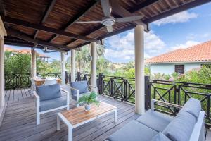 a deck with a couch and chairs and a table at Elegant Getaway for Couples & Friends at Blue Bay in Willemstad
