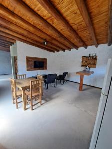 a living room with a wooden ceiling and a table and chairs at Escapada perfecta con pileta privada- 2 personas in Ciudad Lujan de Cuyo