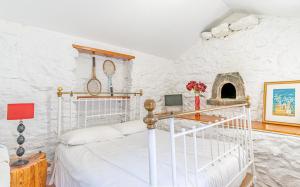 a bedroom with a bed in a white room at Vila Pitaias in Estreito da Calheta