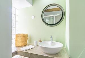 a bathroom with a white sink and a mirror at Vila Pitaias in Estreito da Calheta +41 photos
