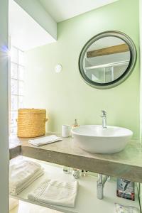 a bathroom with a white sink and a mirror at Vila Pitaias in Estreito da Calheta