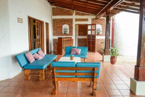 a patio with two blue couches and a table at Casa Ruth in San Juan del Sur
