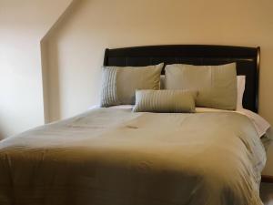 una cama grande con sábanas y almohadas blancas en Modern, Amish-Built Farmhouse, 3 bedrooms sleeps 6, en Medina
