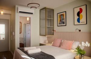 um quarto com uma cama com almofadas cor-de-rosa em Luxo Novo e Aconchegante entre Pinheiros e Jardins em São Paulo