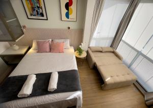 um pequeno quarto com uma cama e um sofá em Luxo Novo e Aconchegante entre Pinheiros e Jardins em São Paulo