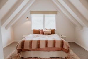 a bedroom with a bed with a large window at Birch Cottage Trentham in Trentham