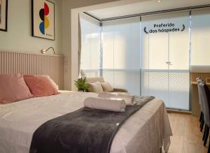 um quarto com uma cama grande e uma janela grande em Luxo Novo e Aconchegante entre Pinheiros e Jardins em São Paulo