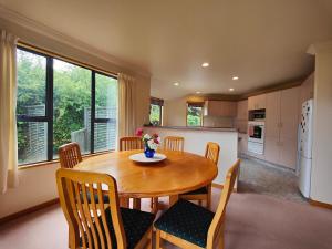 a kitchen and dining room with a wooden table and chairs at Dusky Delight in Te Anau