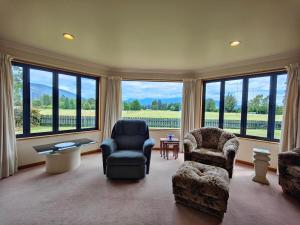 a living room with chairs and a large window at Dusky Delight in Te Anau