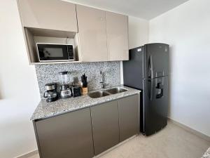 a kitchen with a sink and a refrigerator at Altomare Depa 1804 in Mazatlán +11 photos