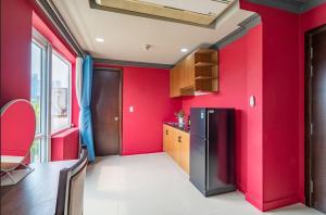 a kitchen with red walls and a refrigerator at La Serena Boutique Hotel in Ho Chi Minh City