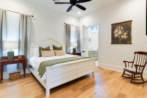 ein Schlafzimmer mit einem weißen Bett und einem Deckenventilator in der Unterkunft Cajun Country Retreat King Beds Patio Arcade Luxe in Lafayette