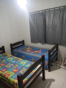 two twin beds in a room with a window at Casa temporada regiao dos lagos São pedro in São Pedro da Aldeia