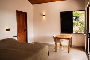 a bedroom with a bed and a table and a television at Finca Aquarius in Monteverde Costa Rica
