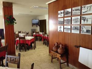a dining room with tables and chairs and a television at Hotel Venta Nueva in Calatañazor