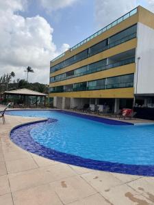 a large swimming pool in front of a building at Cobertura Duplex Pé na Areia 509 Tabatinga Residence in Conde