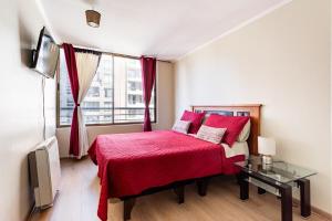 - une chambre avec un lit rouge et une fenêtre dans l'établissement Lindo departamento hasta 6 personas, estacionamiento, à Santiago
