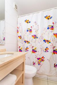 La salle de bains est pourvue d'un rideau de douche avec des papillons colorés. dans l'établissement Lindo departamento hasta 6 personas, estacionamiento, à Santiago