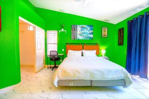 a green bedroom with a bed and a green wall at Private Guestrooms OR Entire Home Rental in North Las Vegas in Las Vegas