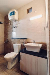 a bathroom with a toilet and a sink at Vista Hills Apartment in Mussoorie