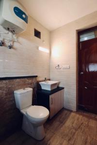 a bathroom with a toilet and a sink at Vista Hills Apartment in Mussoorie