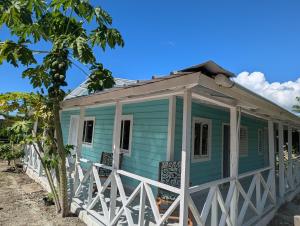 a blue house with a white fence around it at Habitaciones Casa Tinina in Boca Chica